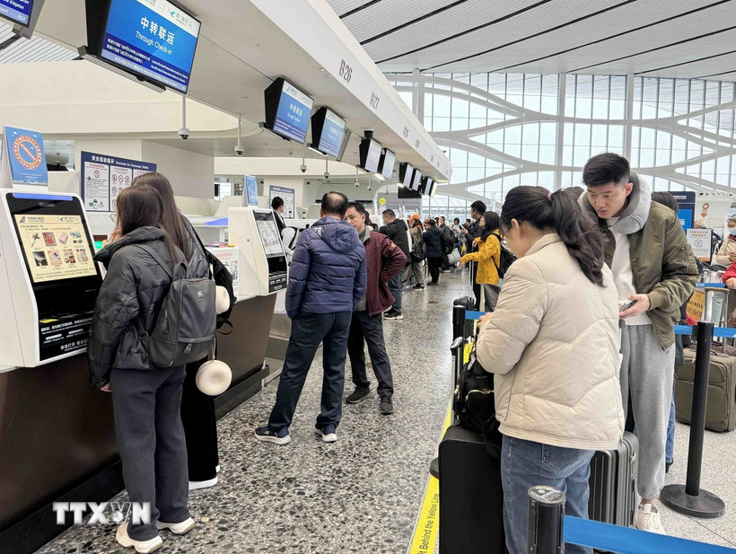 Người dân Trung Quốc làm thủ tục lên máy bay để về quê ăn Tết tại sân bay Đại Hưng - Bắc Kinh. (Ảnh: Công Tuyên/TTXVN)