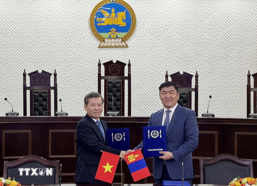 Chánh án Tòa án Nhân dân Tối cao Lê Minh Trí (trái) và Chánh án Tòa án Tối cao Mông Cổ Ganzorig Damdin trao đổi Bản ghi nhớ hợp tác giữa hai bên. (Ảnh: Công Tuyên/TTXVN)