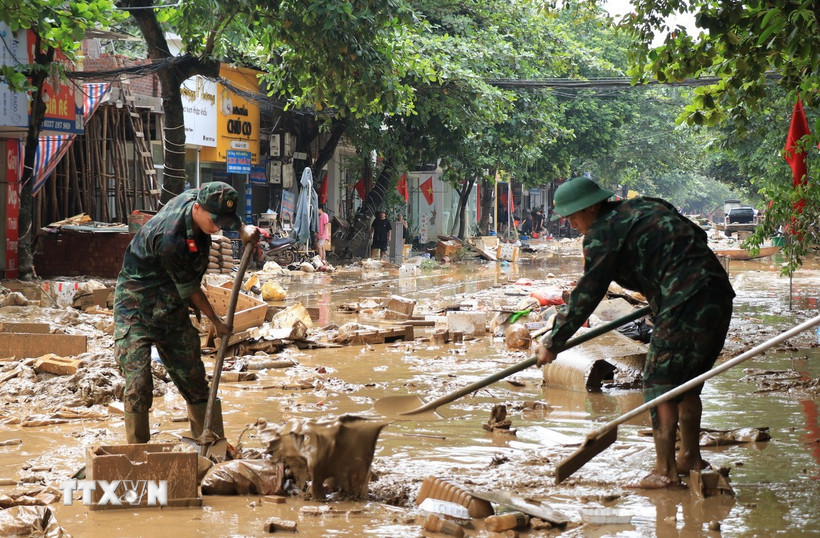 Cán bộ, chiến sỹ Bộ chỉ huy Quân sự tỉnh Lào Cai giúp đỡ người dân vùng ngập lụt khắc phục hậu quả. (Ảnh: Đinh Thùy/TTXVN)