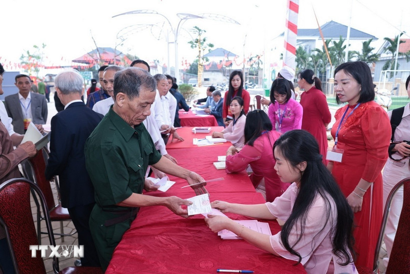 Những cử tri đầu tiên của xã đảo Minh Châu, Hà Nội nhận phiếu bầu cử. (Ảnh: Trần Việt/TTXVN)