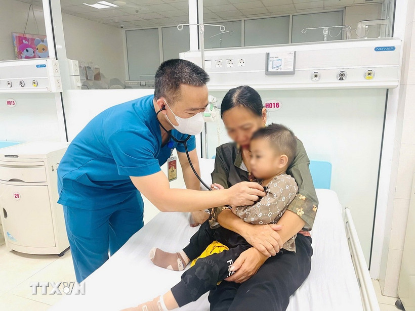 Bác siỹ thăm khám sau khi bệnh nhi được gắp dị vật mắc trong thực quản và sức khỏe dần ổn định. (Ảnh: TTXVN phát)