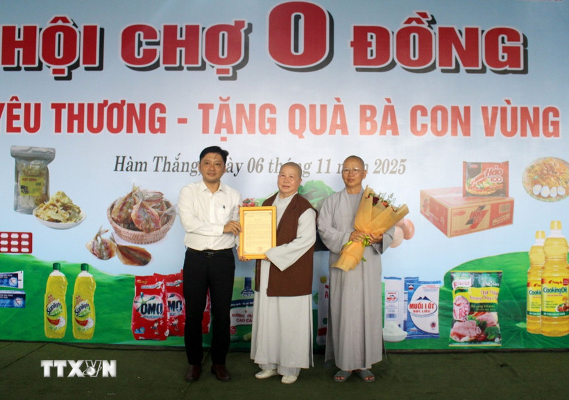 Đại diện Ủy ban Mặt trận Tổ quốc Việt Nam phường Hàm Thắng trao thư cảm ơn cho Ban từ thiện xã hội Giáo hội Phật giáo Việt Nam tỉnh Lâm Đồng. (Ảnh: Hồng Hiếu/TTXVN)