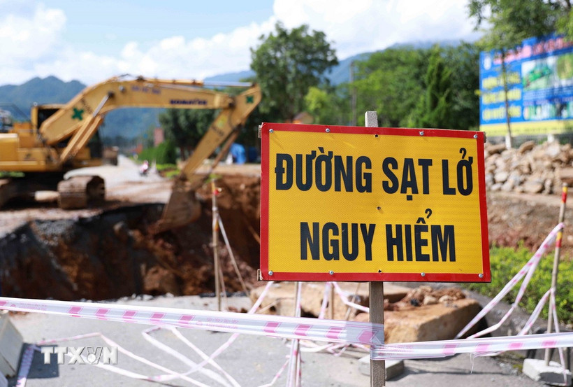 Các đơn vị chức năng cắm cảnh báo nguy hiểm do tình trạng sụt lún tại Km27+120 - Km27+200 trên quốc lộ 4D ở Lai Châu. (Ảnh: Quý Trung/TTXVN)