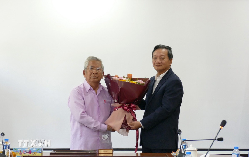 Đại sứ Việt Nam tại Lào Nguyễn Minh Tâm tặng hoa chúc mừng Nghệ sỹ Quốc gia-nhạc sỹ Lào Douangmixay Likaya. (Ảnh: Xuân Tú/TTXVN)