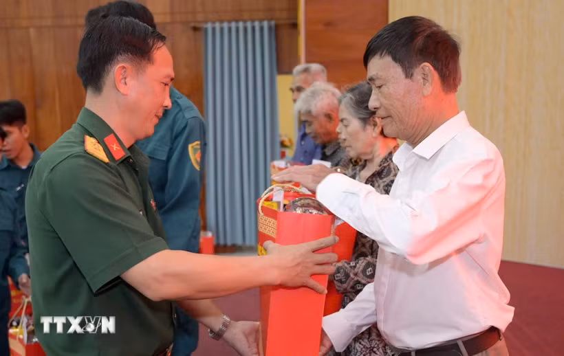 Thừa ủy quyền của Quân ủy Trung ương, Bộ Quốc phòng, Bộ Chỉ huy Quân sự tỉnh An Giang trao quà cho các gia đình chính sách, người có công với cách mạng Châu Thành. (Ảnh: Văn Sĩ/TTXVN)