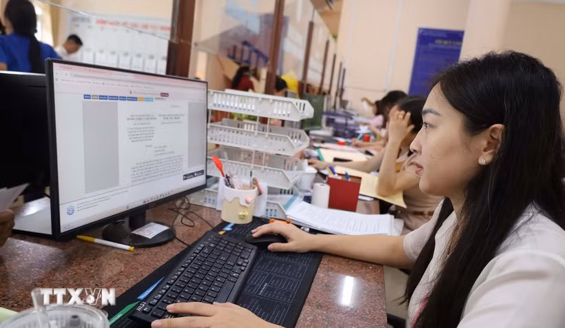 Cán bộ, công chức tại UBND phường Chơn Thành, thành phố Đồng Nai, làm việc ngoài giờ để bảo đảm giải quyết hồ sơ đúng hạn. (Ảnh: Đậu Tất Thành/TTXVN)