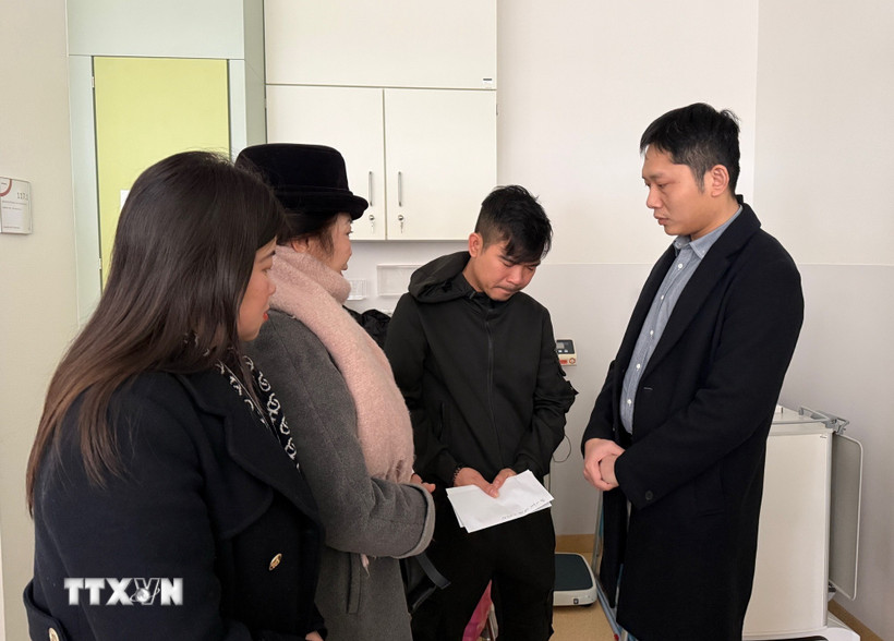 Tham tán Vũ Sơn Tùng (ngoài cùng, bên phải) thăm hỏi và động viên anh Nguyễn Hồng K. (Ảnh: Thu Hằng/TTXVN)