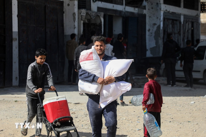 Người dân nhận bột mì viện trợ tại Gaza ngày 2/4/2025. (Ảnh: THX/TTXVN)
