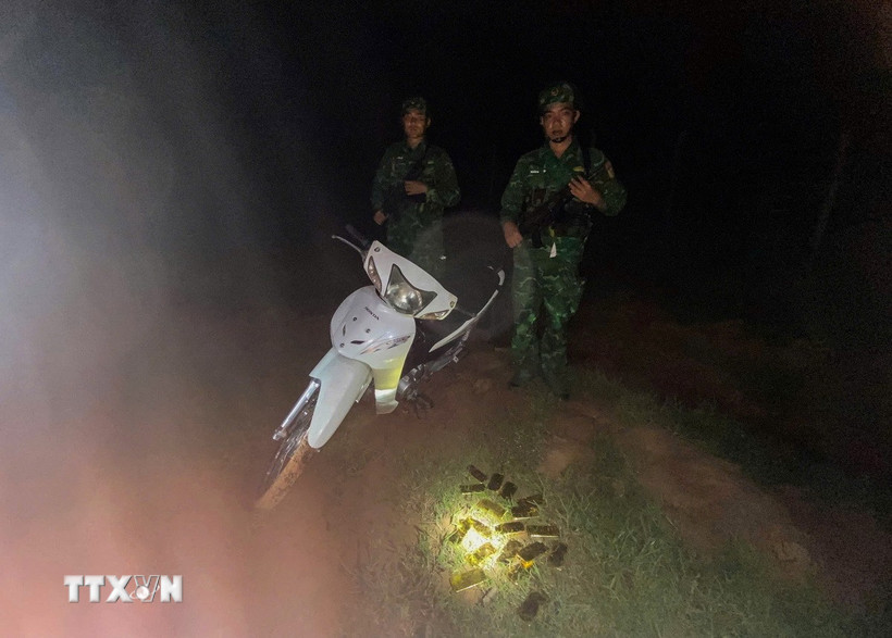 Lực lượng biên phòng thu giữ 18 thỏi vàng và chiếc xe máy do các đối tượng bỏ chạy để lại. (Ảnh: TTXVN phát)