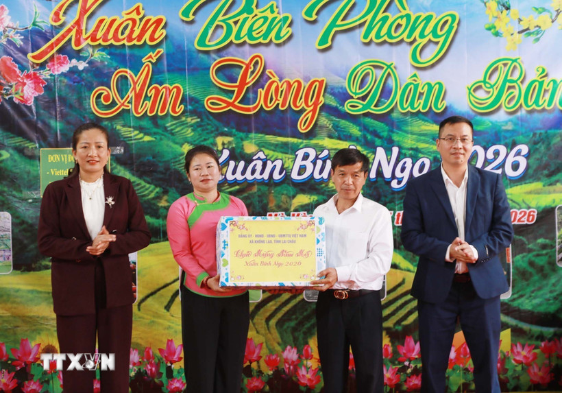 Lãnh đạo xã Khổng Lào trao quà Tết cho đại diện bản Nà Vàng. (Ảnh: Quý Trung/TTXVN)