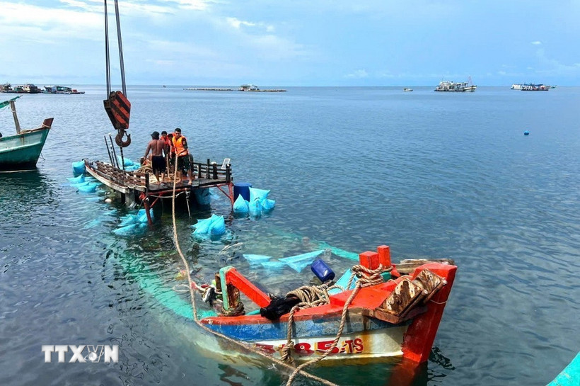 Tàu cá BT 93185 TS bị nạn trên biển được cán bộ, chiến sỹ Đồn Biên phòng Hòn Chuối và ngư dân hỗ trợ lai dắt vào bờ. (Ảnh: Hoàng Tá/TTXVN)