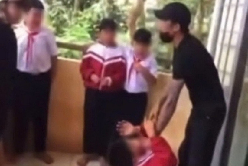 Người đàn ông túm cổ áo, liên tục dọa nạt một học sinh. (Ảnh chụp màn hình)