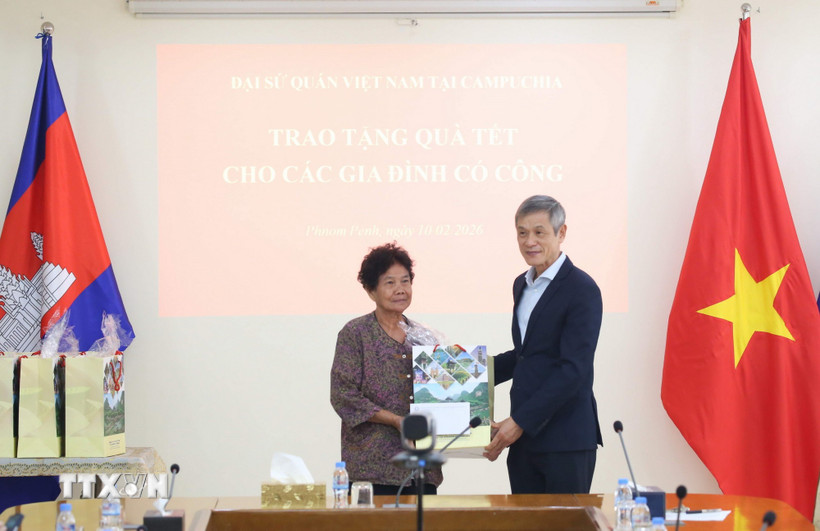 Đại sứ Nguyễn Minh Vũ trao tặng quà Tết cho bà Hà Thị E, có công trong cuộc kháng chiến chống Mỹ cứu nước, được Thủ tướng Chính phủ Việt Nam cấp bằng khen năm 2009. (Ảnh: Huỳnh Thảo/TTXVN)