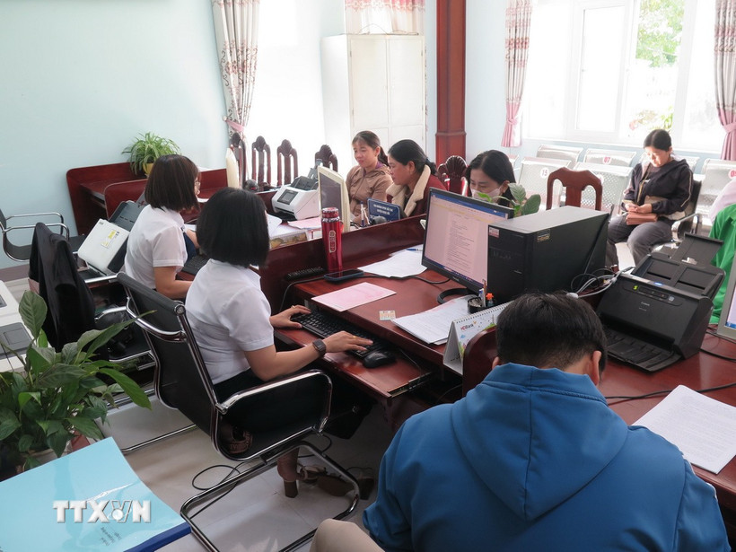 Các cán bộ Trung tâm phục vụ Hành chính công xã Bờ Y giải quyết thủ tục cho người dân. (Ảnh: Dư Toán/TTXVN)