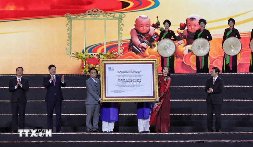 Bà Pauline Tamesis, Điều phối viên thường trú Liên hợp quốc tại Việt Nam trao Bằng của UNESCO ghi danh Nghề làm tranh dân gian Đông Hồ vào Danh sách Di sản văn hóa phi vật thể cần bảo vệ khẩn cấp cho lãnh đạo Bộ Văn hoá, Thể thao và Du lịch. (Ảnh: Danh Lam/TTXVN)