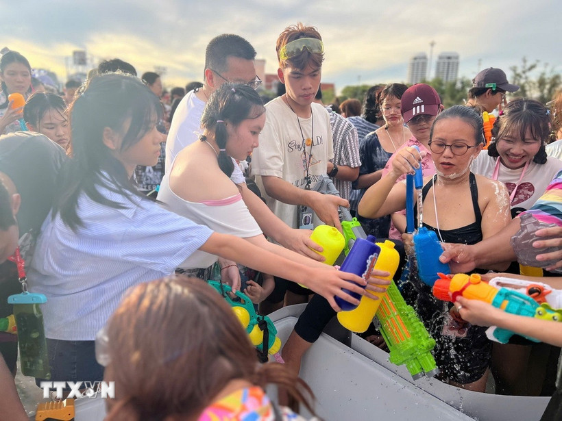 Người tham gia lễ hội chờ lấy nước để té vào nhau - một trong những điểm nổi bật của lễ hội Songkran. (Ảnh: Huy Tiến/TTXVN)