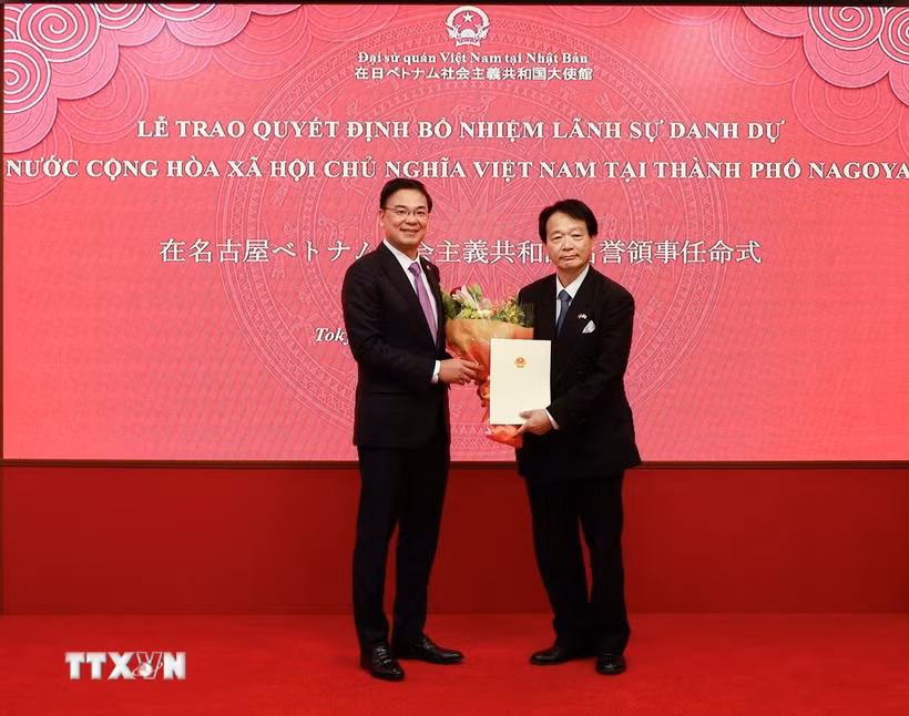 Đại sứ đặc mệnh toàn quyền Việt Nam tại Nhật Bản Phạm Quang Hiệu trao quyết định và tặng hoa chúc mừng GS.TS Nagato Natsume. (Ảnh: Xuân Giao/TTXVN)