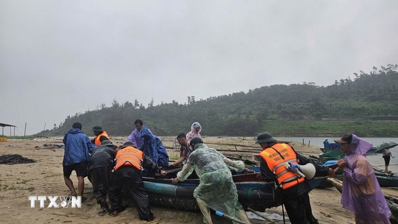 Bộ đội biên phòng giúp dân đưa thuyền vào nơi tránh trú an toàn. (Ảnh: Mai Trang/TTXVN)