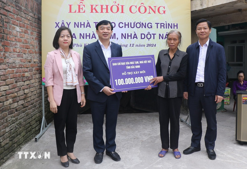 Bà Ngô Thị Sơn (thứ 2 từ phải), khu phố Phù Khê Thượng, phường Phù Khê, thành phố Từ Sơn, tỉnh Bắc Ninh nhận hỗ trợ xây nhà mới từ tỉnh Bắc Ninh. (Ảnh: Thanh Thương/TTXVN)