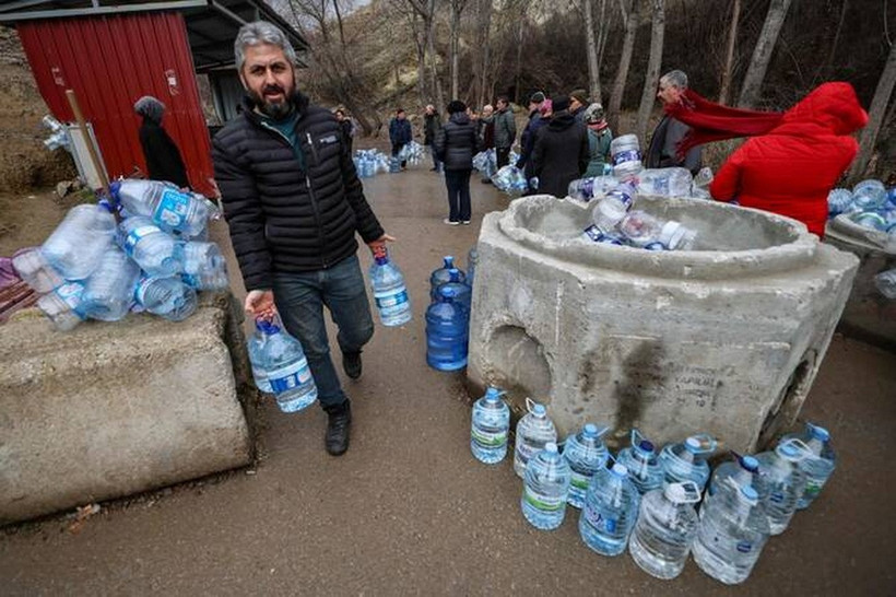 Một người đàn ông mang các chai rỗng đi lấy nước tại Araplar thuộc quận Mamaklar ở Ankara, Thổ Nhĩ Kỳ. (Nguồn: AFP)