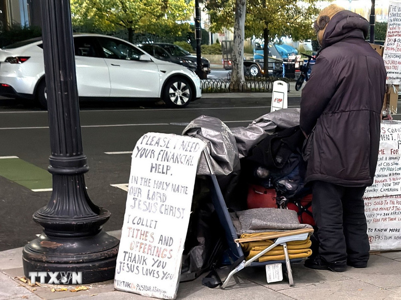 Một người vô gia cư với tấm biển cần giúp đỡ về tài chính trên một tuyến phố ở trung tâm thủ đô Washington D.C. (Ảnh: Ngọc Quang/TTXVN)