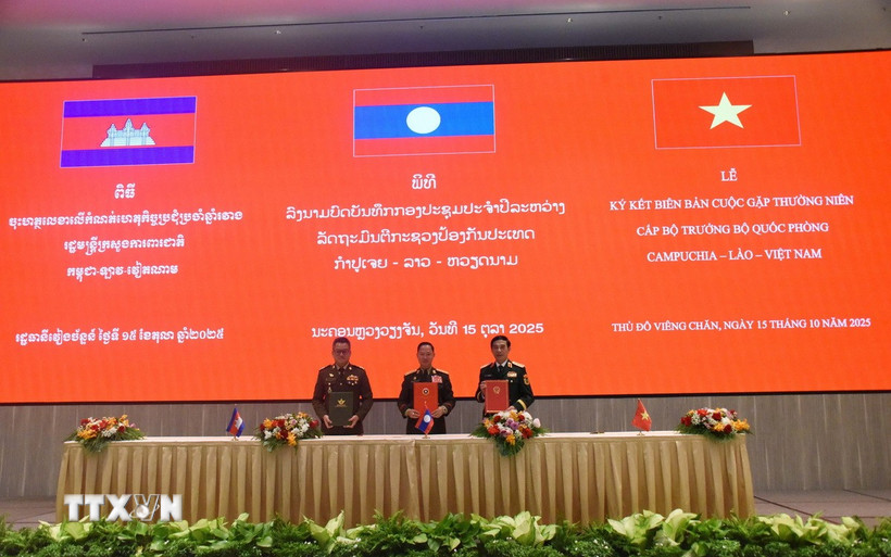 Bộ trưởng Quốc phòng Việt Nam-Lào-Campuchia ký biên bản cuộc gặp. (Ảnh: Xuân Tú/TTXVN)