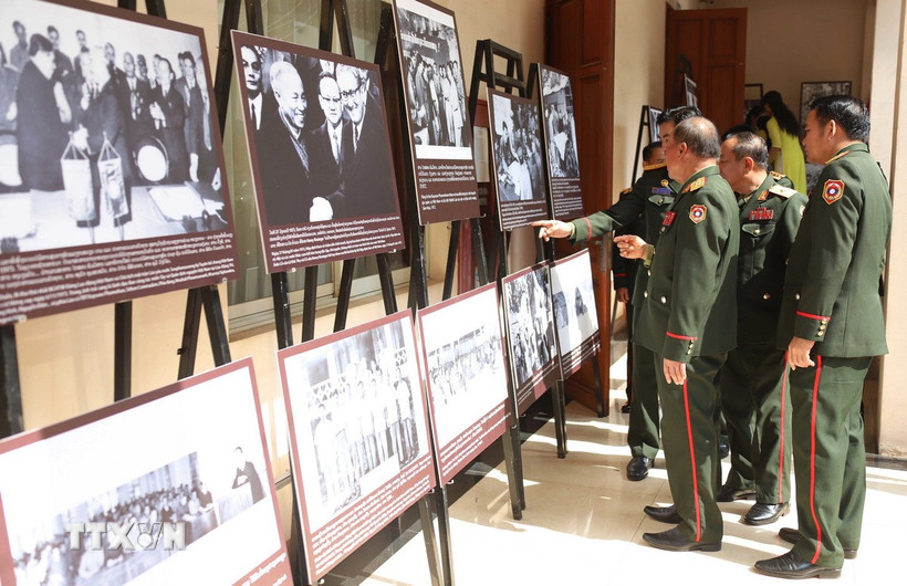 Các đại biểu đại diện Bộ Quốc phòng Lào tham dự tham quan ảnh triển lãm. (Ảnh: Xuân Tú/TTXVN)