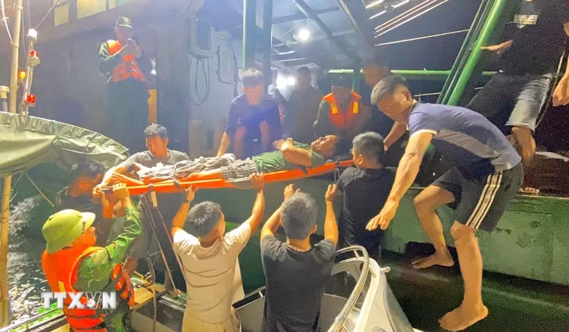 Ngư dân Trần Huy Biên được cán bộ chiến sĩ Đồn Biên phòng Quỳnh Thuận, Bộ đội Biên phòng Nghệ An, cứu hộ, đưa vào bờ cấp cứu an toàn. (Ảnh: TTXVN phát)