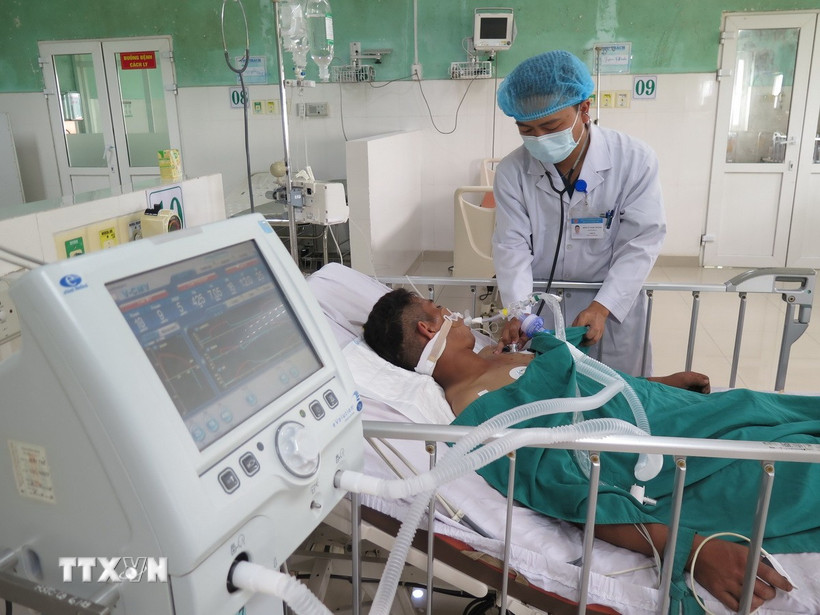 Bác sỹ Bệnh viện Đa khoa tỉnh Quảng Ngãi 2 thăm khám bệnh nhân bị ngộ độc Botulinum. (Ảnh: Dư Toán/TTXVN)