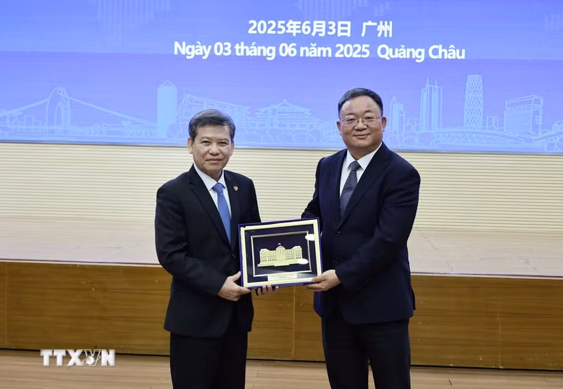 Ông Lê Minh Trí, Chánh án Tòa án Nhân dân Tối cao Việt Nam trao quà lưu niệm tặng Tòa án Nhân dân cấp cao tỉnh Quảng Đông, Trung Quốc. (Ảnh: Công Tuyên/TTXVN)