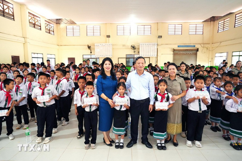 Đại sứ Nguyễn Minh Tâm và phu nhân chụp ảnh cùng với đại diện nhà trường và các học sinh Trường song ngữ Lào - Việt Nam Nguyễn Du. (Ảnh: Đỗ Bá Thành/TTXVN)