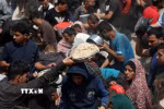 Người dân nhận thực phẩm cứu trợ tại Gaza. (Ảnh: THX/TTXVN)