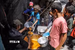 Các em nhỏ nhận thực phẩm cứu trợ tại Jabalia, Dải Gaza. (Ảnh: THX/TTXVN)