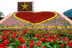 Tiểu cảnh “Trái tim” kết hợp cùng cờ đỏ, sao vàng được xếp hình từ khoảng 1.700 chậu hoa tươi các loại. (Ảnh: Nhựt An/TTXVN)