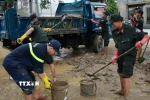 Đoàn công tác Công an tỉnh Quảng Trị có mặt tại thành phố Huế và khẩn trương tiến hành dọn vệ sinh môi trường, đẩy bùn đất tại các cơ quan, đơn vị. (Ảnh: TTXVN phát)