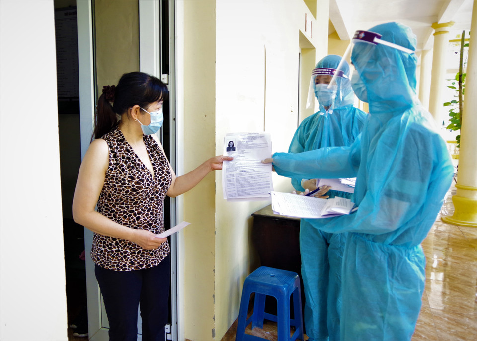 Các chiến sỹ và công dân xem tiểu sử ứng cử viên niêm yết tại khu cách ly phòng, chống dịch COVID-19 Trường Quân sự Bộ Tư lệnh Thủ đô Hà Nội. (Ảnh: TTXVN phát)