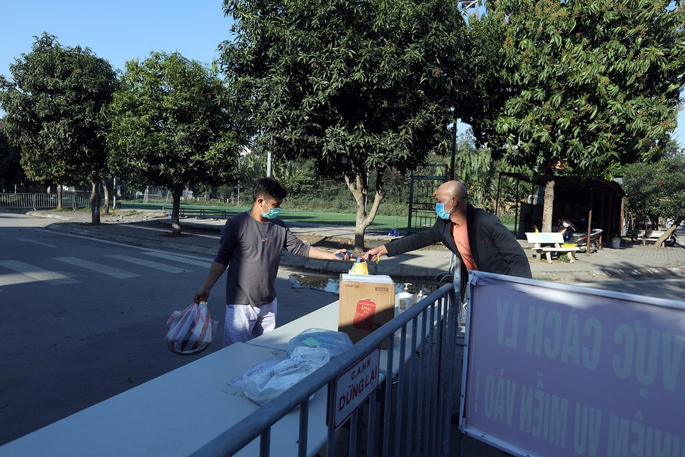 Bàn giao nhu yếu phẩm tại khu cách ly. (Ảnh: Phan Tuấn Anh/TTXVN)