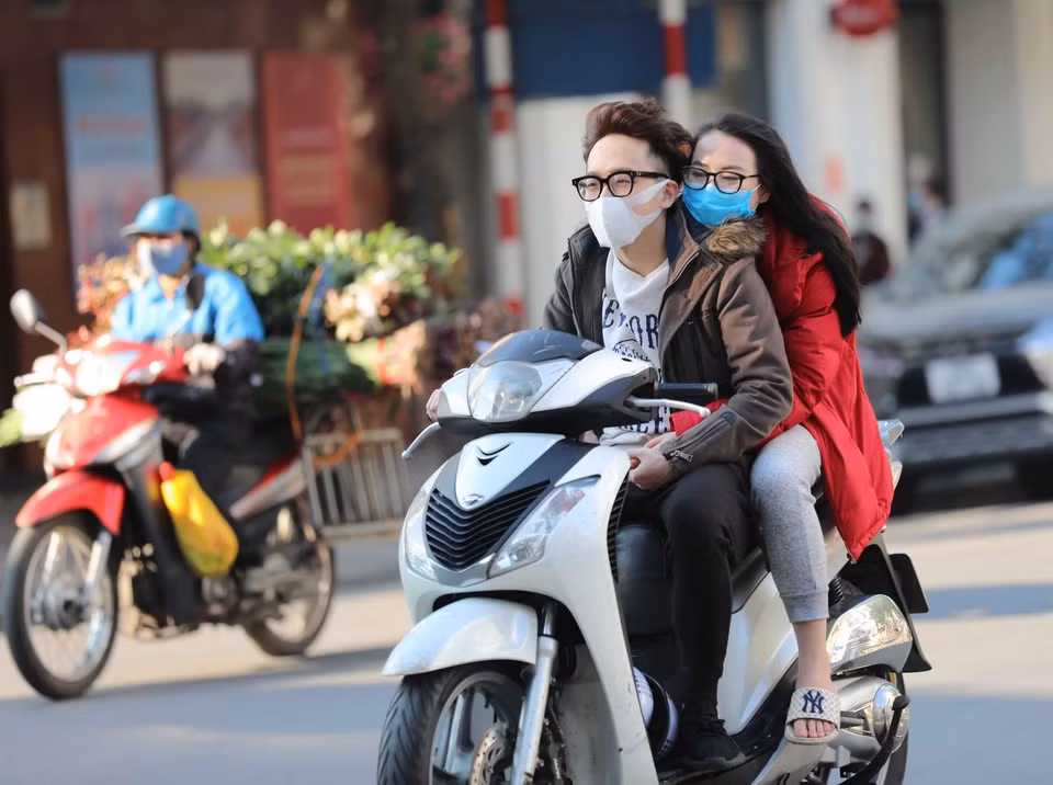 Hai bạn trẻ chủ quan, không thực hiện đội mũ bảo hiểm khi điều khiển và ngồi trên xe gắn máy (ảnh chụp lúc 16h, ngày 10/2/2021 trên phố Ngô Quyền, Hà Nội). (Ảnh: Thanh Tùng/TTXVN)