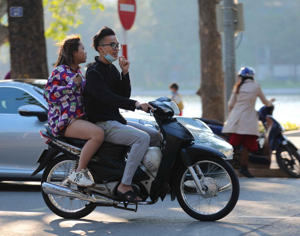 Một bộ phận giới trẻ thường xuyên chủ quan, không thực hiện đội mũ bảo hiểm khi điều khiển và ngồi trên xe gắn máy (ảnh chụp lúc 16h, ngày 10/2/2021 trên phố Đinh Tiên Hoàng, Hà Nội). (Ảnh: Thanh Tùng/TTXVN)