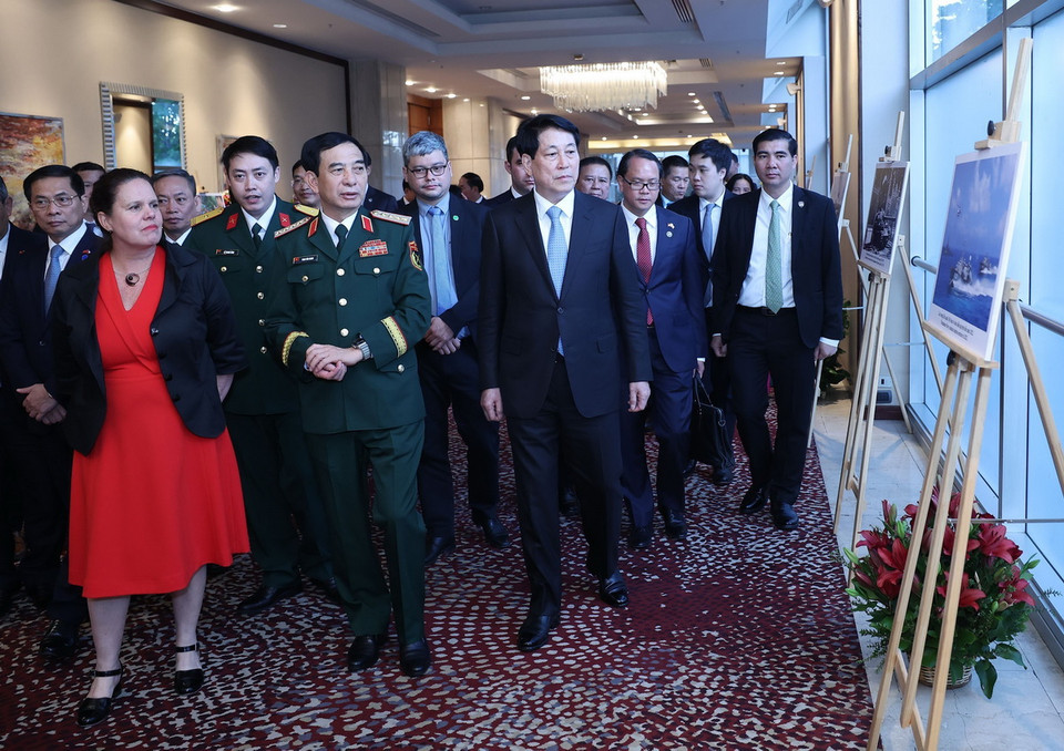 Chủ tịch nước Lương Cường và các đại biểu xem trưng bày ảnh về thành tựu của Quân đội Nhân dân Việt Nam. (Ảnh: Lâm Khánh/TTXVN)