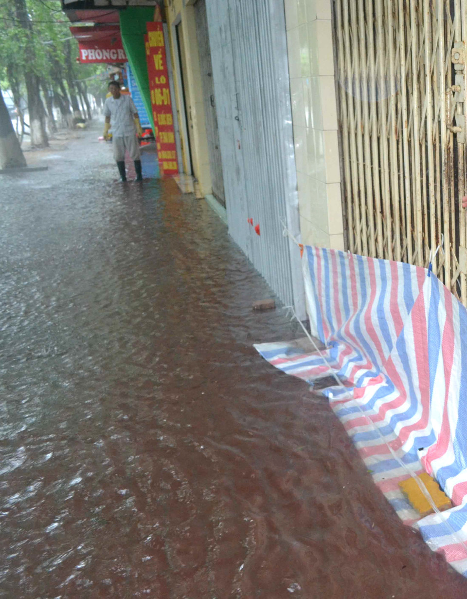 Người dân ngăn nước tràn vào nhà tại thành phố Thái Bình. (Ảnh: Thu Hoài/TTXVN)