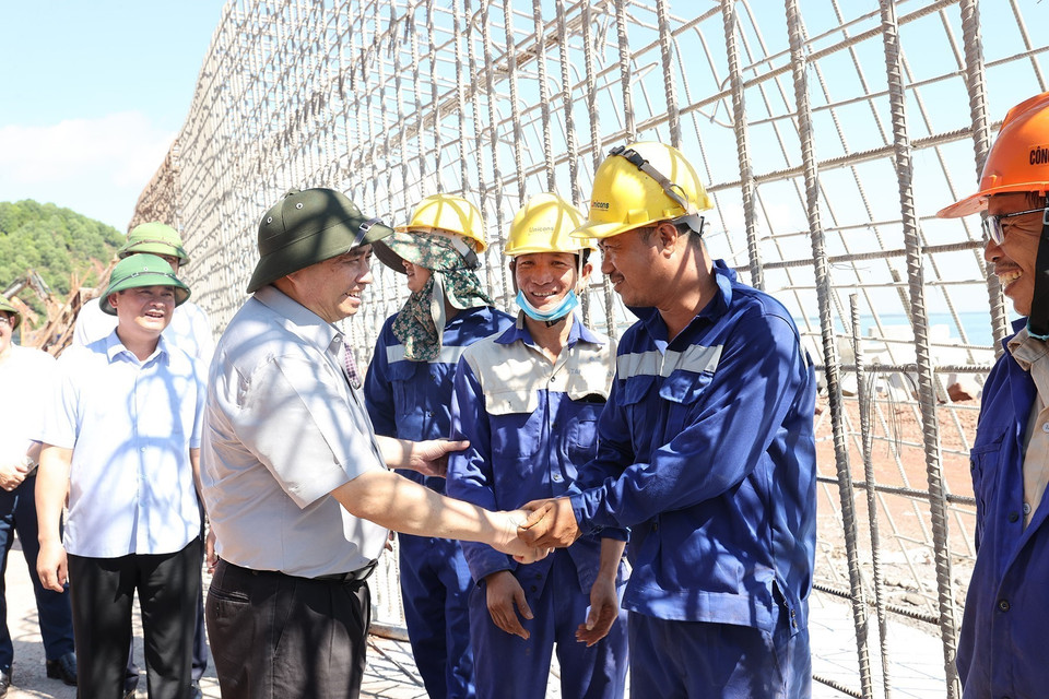 Thủ tướng Phạm Minh Chính động viên công nhân đang thi công tuyến đường giao thông ven biển đoạn từ Nghi Sơn (Thanh Hóa)-Cửa Lò (Nghệ An). (Ảnh: Dương Giang/TTXVN)