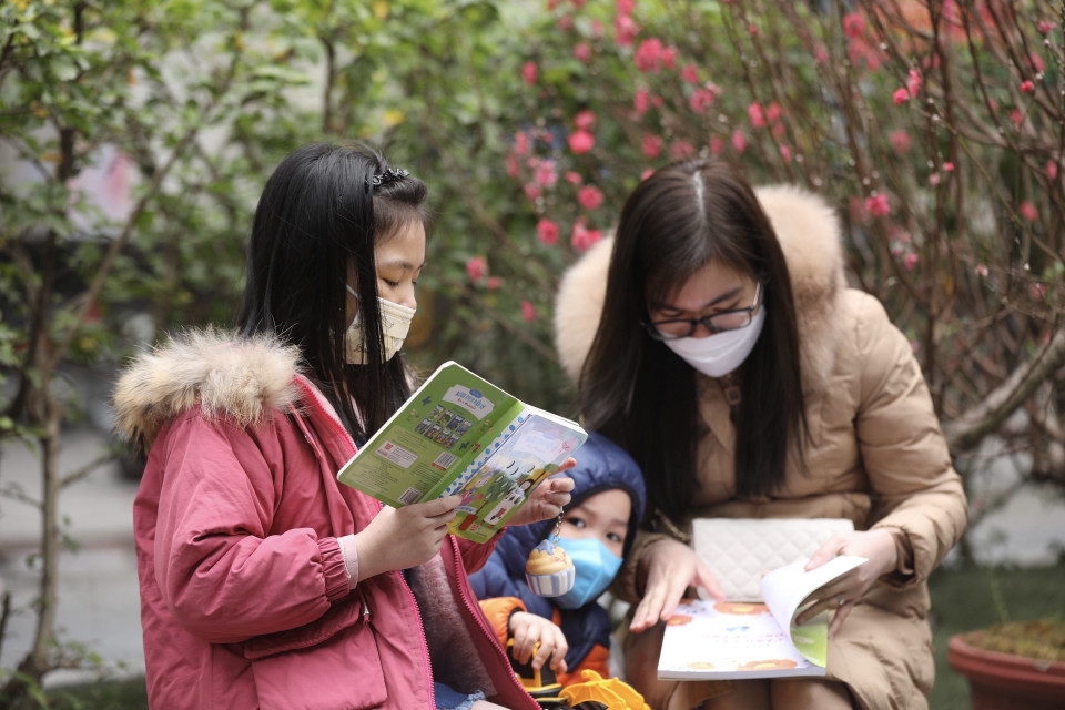 Thưởng thức những quyển sách vừa chọn mua. (Ảnh: Minh Quyết/TTXVN)