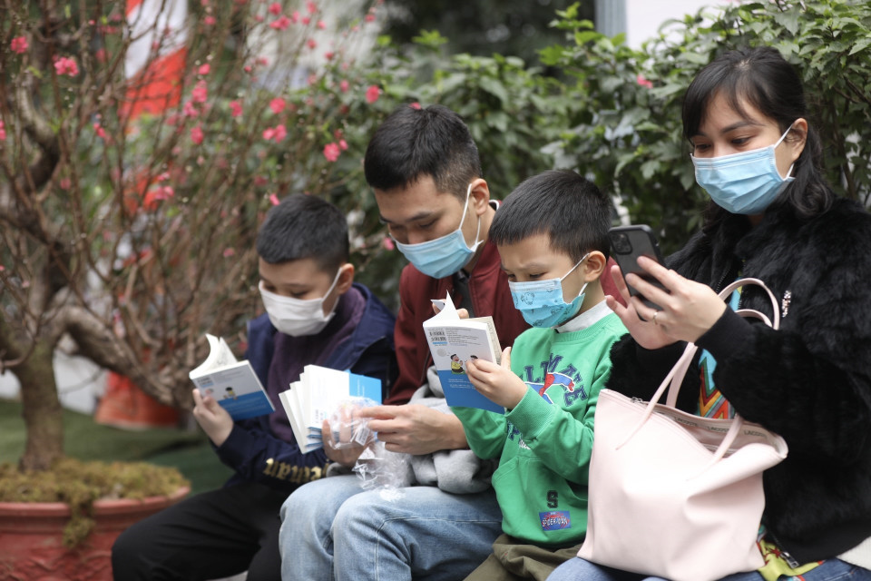 Các bạn nhỏ thưởng thức những quyển sách vừa được mua tại Phố sách. (Ảnh: Minh Quyết/TTXVN)