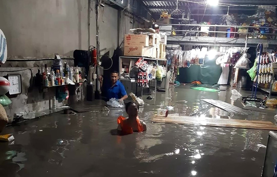 Người dân phường Hà Khánh, thành phố Hạ Long, đau xót khi hàng hóa ngập trong nước do mưa lớn đêm 25/8. (Ảnh: TTXVN phát)