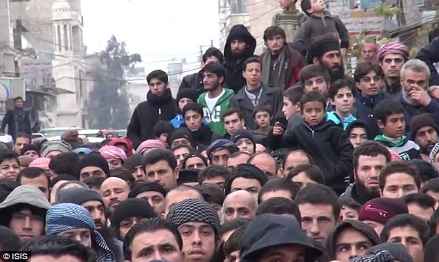 Những người đàn ông Syria tới xem cảnh đóng đinh gián điệp Assad tại trung tâm thành phố. (Nguồn: DM)