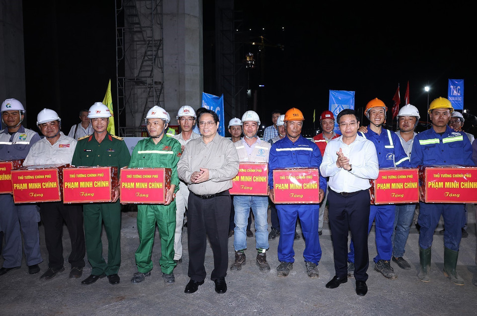 Thủ tướng Phạm Minh Chính tặng quà cho công nhân thi công cầu Rạch Miễu 2, thành phố Mỹ Tho, tỉnh Tiền Giang. (Ảnh: Dương Giang/TTXVN)