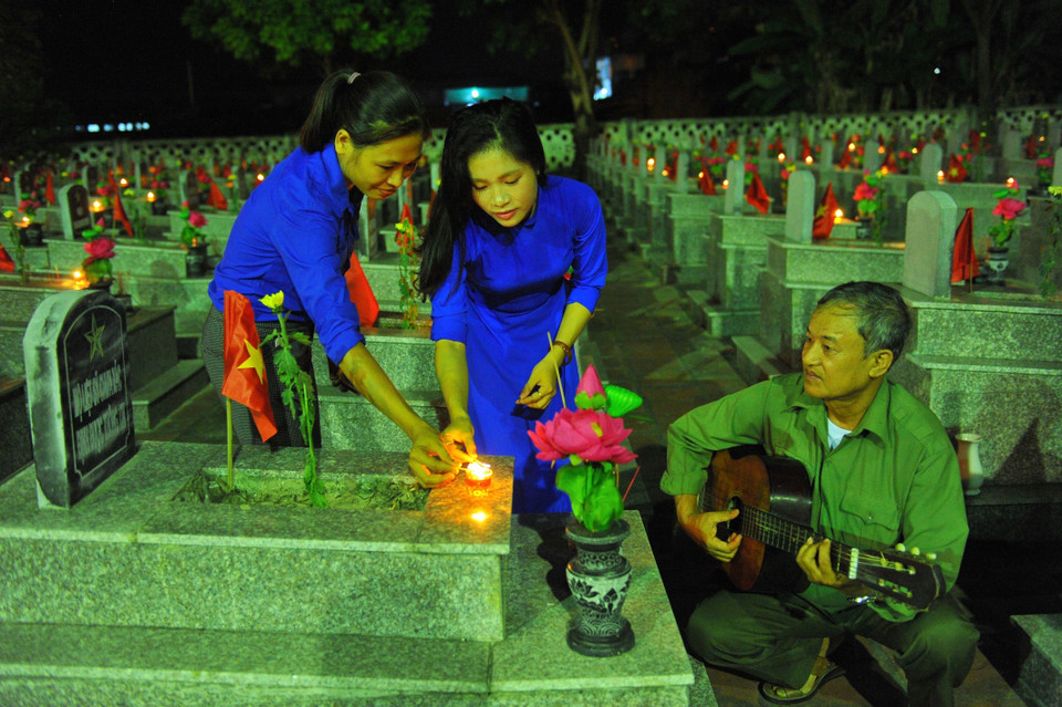  Đoàn viên, thanh niên huyện Yên Mô (Ninh Bình) thắp nến tri ân các Anh hùng liệt sỹ tại Nghĩa trang Liệt sỹ huyện Yên Mô. (Ảnh: Minh Đức/TTXVN)