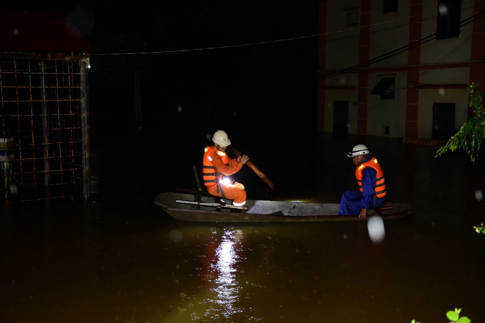 Công nhân Công ty Điện lực huyện Sóc Sơn kiểm tra an toàn để cấp điện trở lại cho các hộ dân thôn Lương Phúc ở ngoài đê Hữu Cầu, thuộc xã Việt Long, huyện Sóc Sơn từ 21h ngày 12/9. (Ảnh: TTXVN phát)