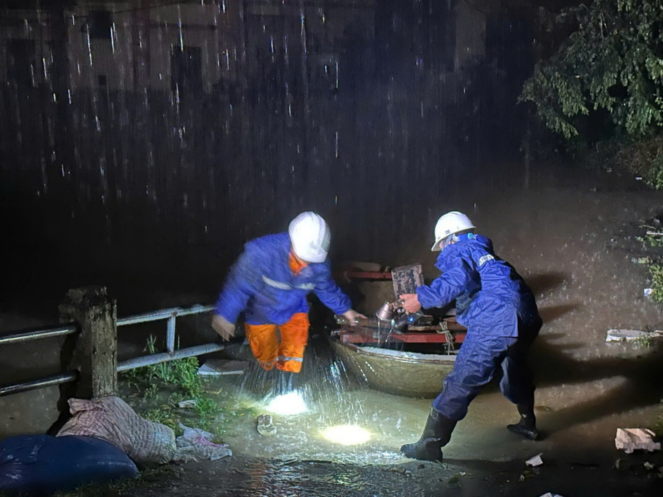 Công nhân Công ty Điện lực huyện Sóc Sơn kiểm tra an toàn để cấp điện trở lại cho các hộ dân thôn Lương Phúc ở ngoài đê Hữu Cầu, thuộc xã Việt Long, huyện Sóc Sơn từ 21h ngày 12/9. (Ảnh: TTXVN phát)